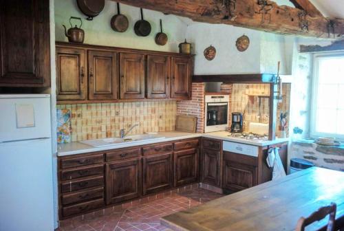 a kitchen with wooden cabinets and a counter top at Maison spacieuse proche du centre de Landevieille + jardin clôturé in Landevieille