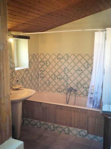 une salle de bain avec une baignoire et un lavabo dans l'établissement Maison spacieuse proche du centre de Landevieille + jardin clôturé, à Landevieille
