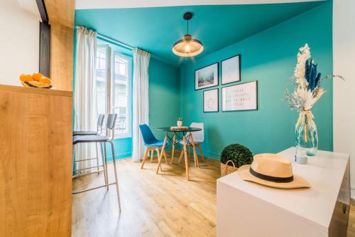 ein Wohnzimmer mit blauen Wänden und einem Tisch in der Unterkunft LESTANG #2 - Appartement Contemporain - 1 Chambre in Brive-la-Gaillarde