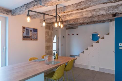 une salle à manger avec une table en bois et des chaises jaunes dans l'établissement Échoppe Briviste - 1 Chambre, à Brive-la-Gaillarde