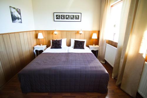a hotel room with two beds and two lamps at Borealis Hotel in Selfoss
