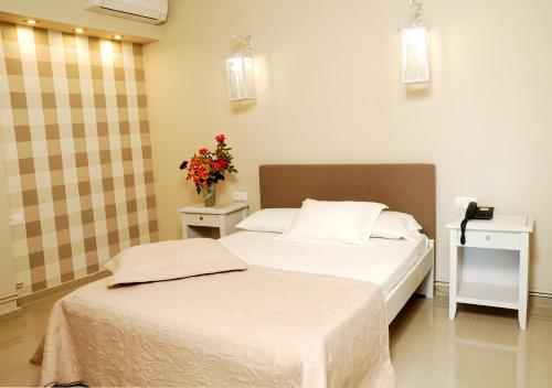 two beds in a bedroom with flowers on the wall at Ariadnes Holiday Accommodation in Apidias Lakos