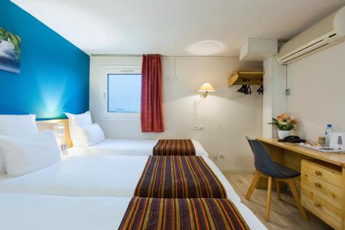 a hotel room with a bed and a desk at Comfort Hotel Montlucon in Montluçon