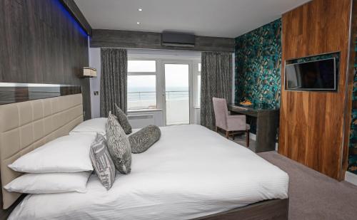 a bedroom with a large white bed with a window at Cumberland Hotel - OCEANA COLLECTION in Bournemouth
