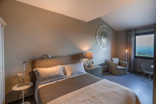a bedroom with a bed and a clock on the wall at Villa Sassolini Mini Apartament in Montevarchi