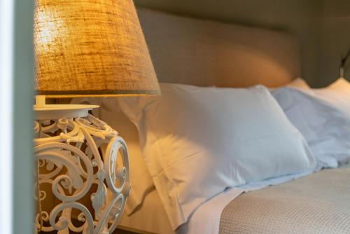 a bed with a lamp next to a bed with white pillows at Villa Sassolini Mini Apartament in Montevarchi