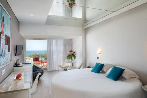 a bedroom with a large white bed and a window at Faros Hotel Ayia Napa in Ayia Napa