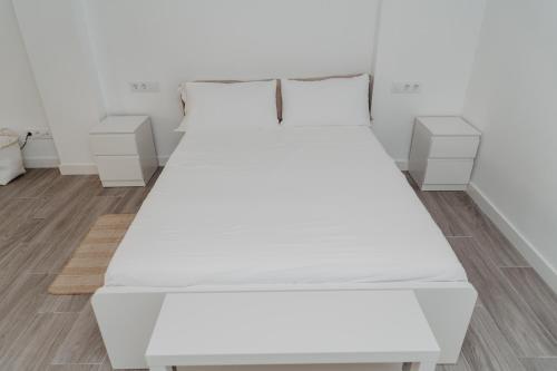 a large white bed in a room with wooden floors at Charming loft next to wonders of Cordoba in Córdoba