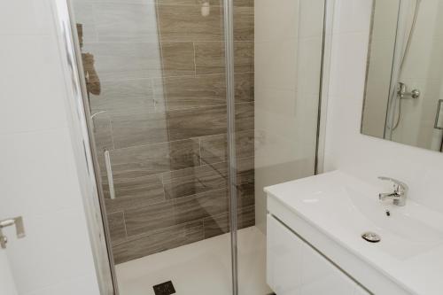 a white bathroom with a shower and a sink at Charming loft next to wonders of Cordoba in Córdoba