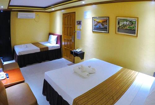 a hotel room with two beds with towels at RedDoorz Plus @ Taj Hotel Tuguegarao in Tuguegarao City