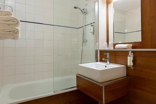 a bathroom with a sink and a shower at Comfort Hotel Lille Lomme in Lomme
