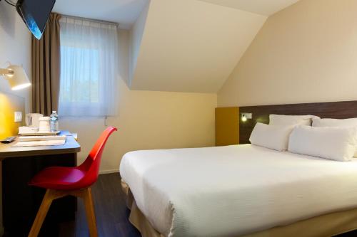 een hotelkamer met een bed en een rode stoel bij Comfort Hotel Lille Lomme in Lomme