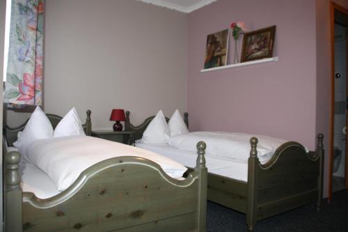 1 dormitorio con 2 camas y almohadas blancas en Hotel Gasthaus Wangerhof, en Augsburg