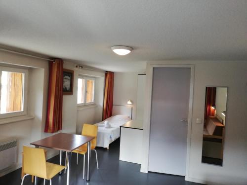 a hotel room with a bed and a table and chairs at Village vacances de Val d'Isère in Val dʼIsère