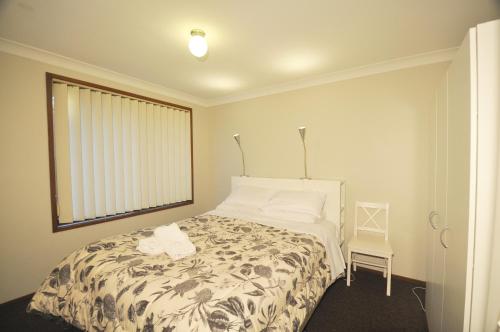 a bedroom with a bed and a window at Katoomba Townhouses in Katoomba