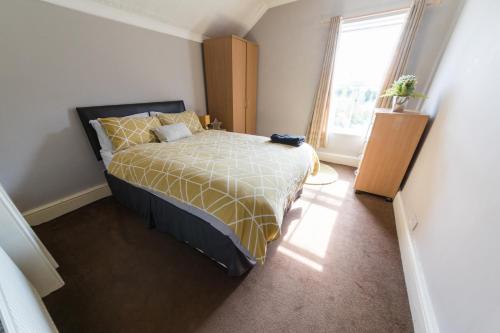 1 dormitorio con cama y ventana en High spec team accommodation w. Super fast wifi, en Bedford