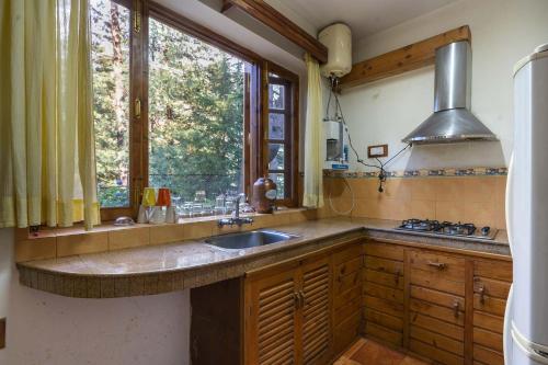 a kitchen with a sink and a window at StayVista at Casa Bella Vista- Luxury 6 BR close to Mall Road with Bonfire and View in Manāli
