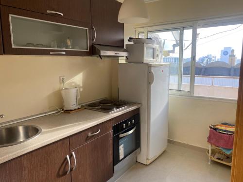 a kitchen with a white refrigerator and a sink at Appartment Anjou in Casablanca
