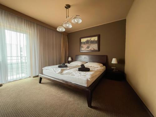 a bedroom with a bed and a large window at Penzion Benedikti in Prievidza