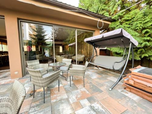 a patio with chairs and a table and an umbrella at Penzion Benedikti in Prievidza