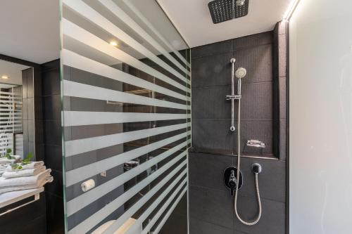 a bathroom with a shower with black and white stripes at Faros Hotel Ayia Napa in Ayia Napa