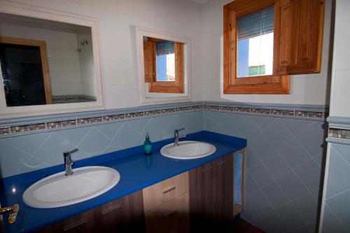 een badkamer met 2 wastafels en 2 spiegels bij El mirador del norte in Cortez de Pallas