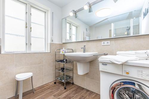 uma casa de banho com um lavatório e uma máquina de lavar roupa em fewo1846 - Gerty Molzen - komfortable 2-Zimmer-Wohnung mit Terrasse im Stadtzentrum em Flensburg