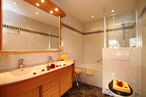 un bagno con lavandino, vasca e doccia di Hotel Metzgerwirt a Fieberbrunn