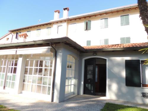 an exterior view of a white building at Ginkgo Guest House in Ronchis