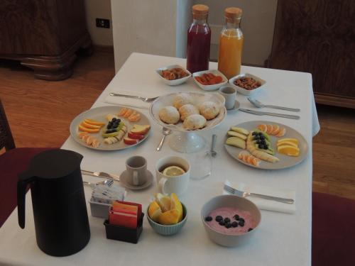 a white table with plates of food on it at Ginkgo Guest House in Ronchis