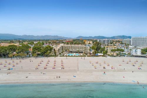 a beach with a lot of people and the water at VIVA Golf Adults Only 18+ in Port d'Alcudia