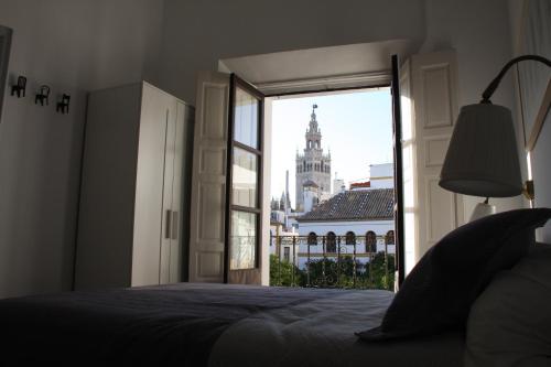 - une chambre avec un lit et une vue sur un bâtiment dans l'établissement Apartamentos en la Plaza Doña Elvira, 7, à Séville