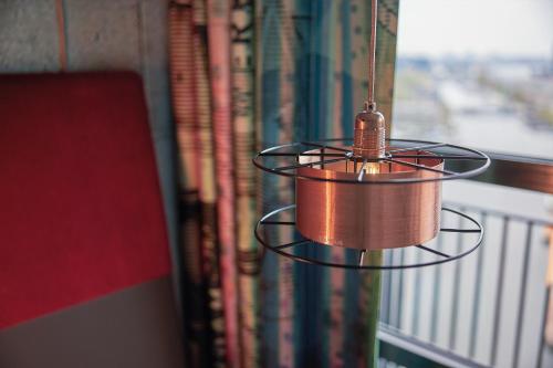 a lamp hanging from a window next to books at Inntel Hotels Amsterdam Landmark in Amsterdam