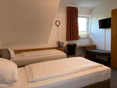 a hotel room with two beds and a desk at Haus Mühlenbrock in Schermbeck