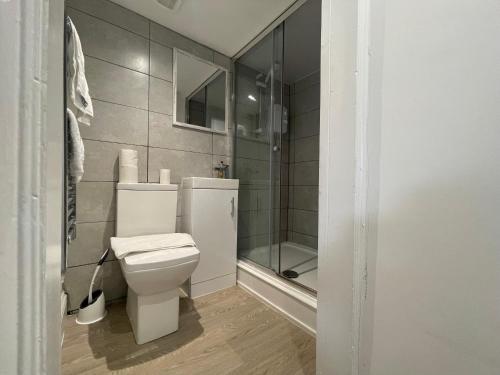 a bathroom with a toilet and a glass shower at Queen Street Apartments in Wolverhampton