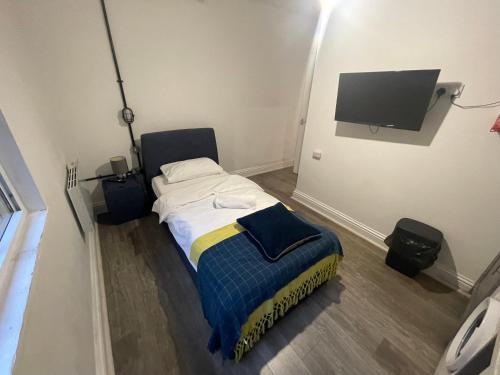 a small bedroom with a bed and a flat screen tv at Queen Street Apartments in Wolverhampton