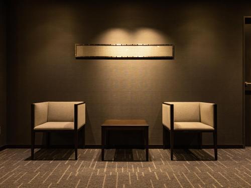 two chairs and a table in a room at Tenza Hotel at Hakata Station in Fukuoka