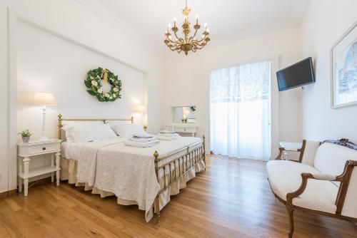 Un dormitorio con una cama grande y una lámpara de araña. en The Koukaki Residence, en Atenas