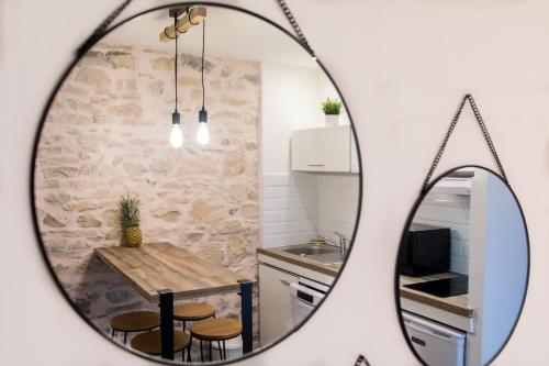 a mirror reflecting a kitchen with a table and chairs at Appartement Cosy Nîmes-Centre in Nîmes