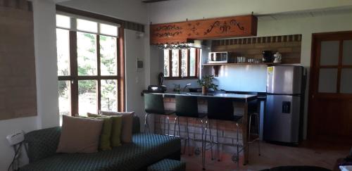 a kitchen with a refrigerator and a couch and a counter at Refugio Villa Emilio in Villa de Leyva