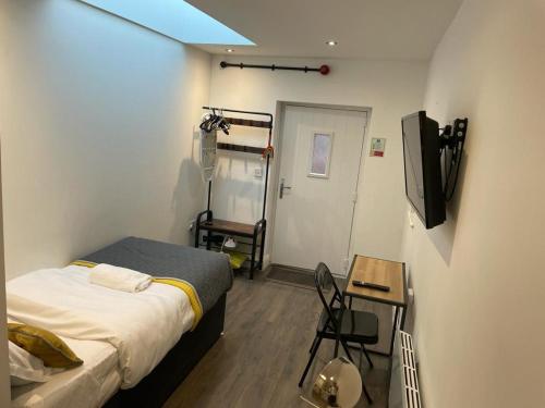 a bedroom with a bed and a table and a television at Queen Street Apartments in Wolverhampton