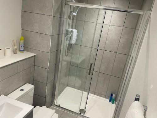 a shower with a glass door in a bathroom at Queen Street Apartments in Wolverhampton
