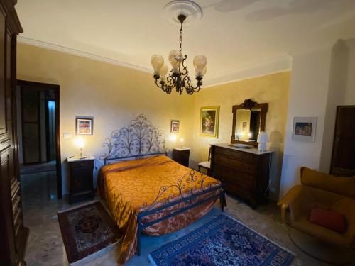 a bedroom with a bed and a chandelier at Appartamento centralissimo con vista sulla città in LʼAquila