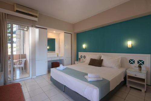 a bedroom with a large bed with a blue wall at Hermes Hotel in Kissamos