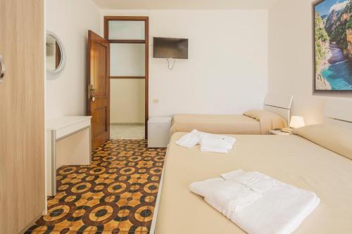 a room with a bed with two white towels on it at Hotel Rosy in Battipaglia