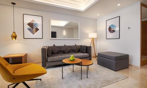 a living room with a couch and a chair at Grupotel Playa de Palma Suites & Spa in Playa de Palma