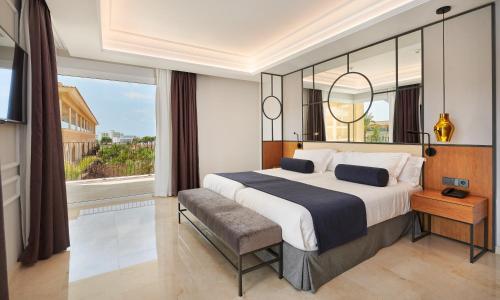 a bedroom with a large bed and a large window at Grupotel Playa de Palma Suites & Spa in Playa de Palma