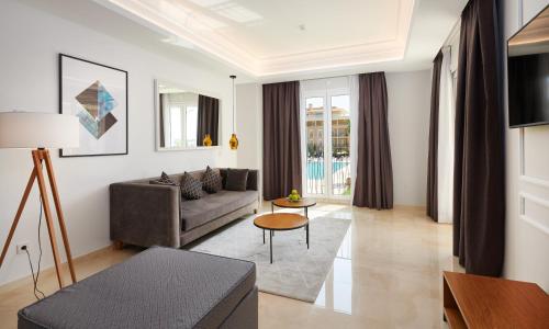a living room with a couch and a table at Grupotel Playa de Palma Suites & Spa in Playa de Palma