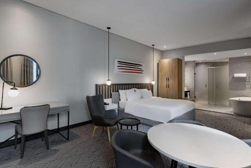 a hotel room with a bed and a table and chairs at Radisson Lagos Ikeja in Lagos