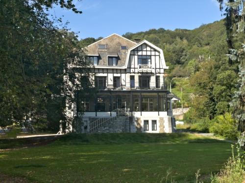 a large white house on a hill with trees at Villa Gracia in Namur